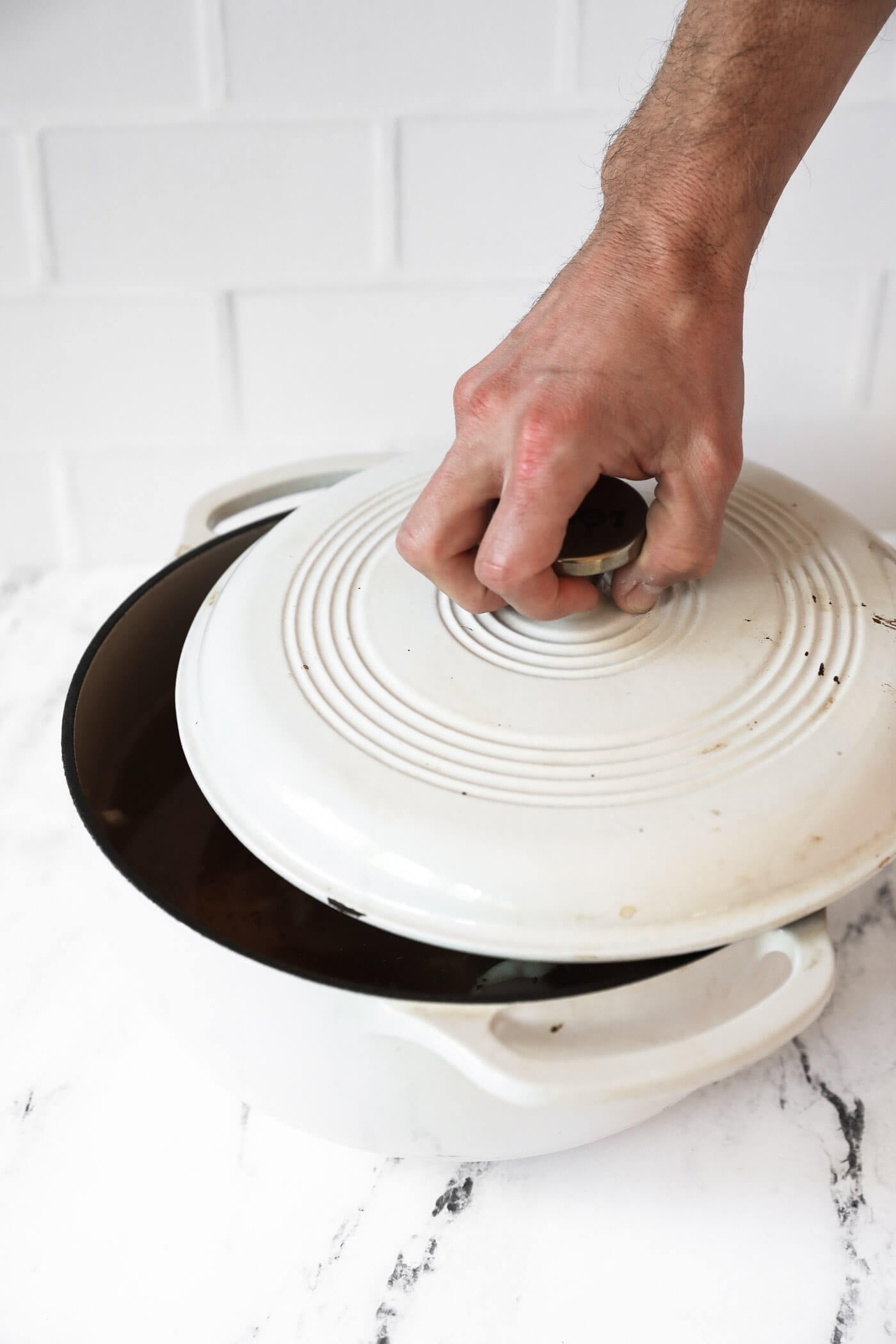 Putting a lid on a dutch oven to simmer over medium to low heat.