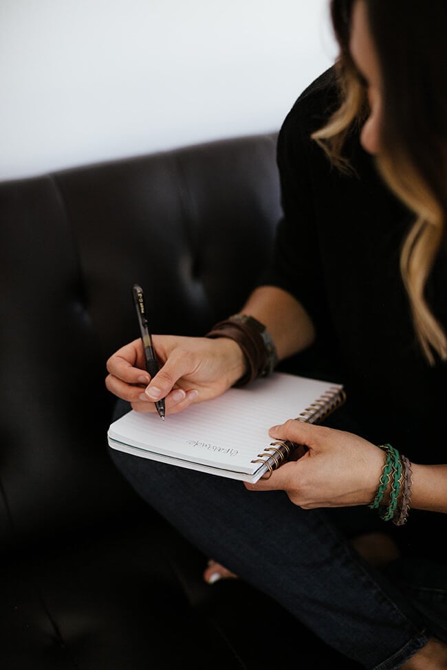 Female sitting on a couch journaling
