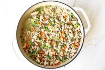 Chicken, peas, carrots and celery in a skillet with broth
