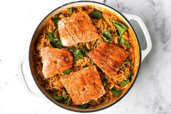 Cajun salmon pasta in a skillet once fully cooked. Pasta, salmon, spinach and a creamy cajun spiced sauce.