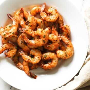 Overhead image of plate os smoked shrimp with seasonings and tails on