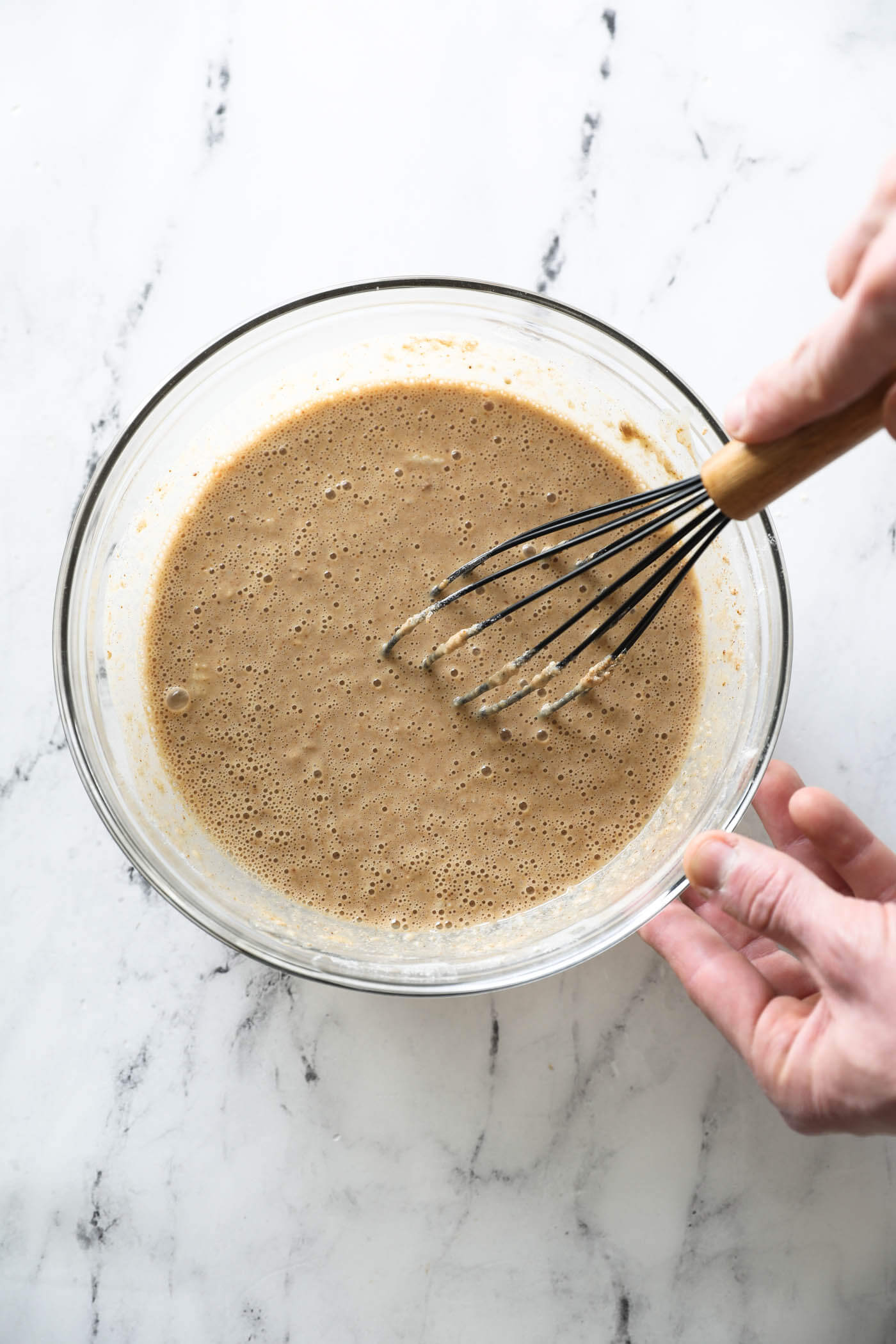 The zucchini bread batter whisked in a mixing bowl.