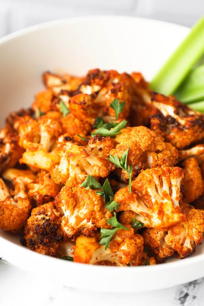 Close up of air fryer buffalo bites in a bowl with parsley topping