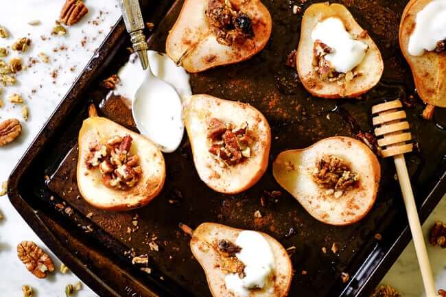 Easy baked pears on a cookie sheet with cinnamon, chopped nuts, granola, honey and coconut yogurt. 