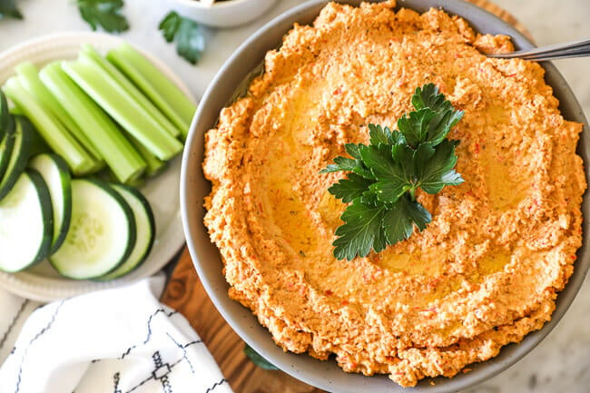 Easy cauliflower hummus in bowl with veggies on side horizontal pic