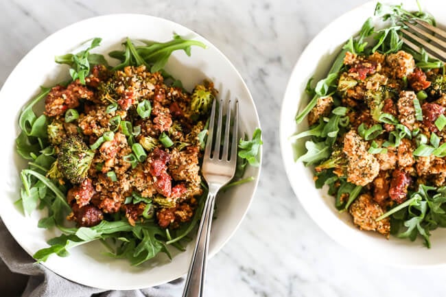 Easy chicken and chorizo bake with greens in bowls and fork overhead horizontal shot