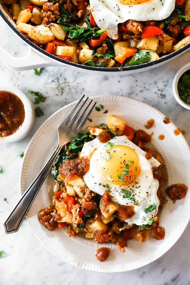 easy chorizo hash on a plate with eggs and salsa on top
