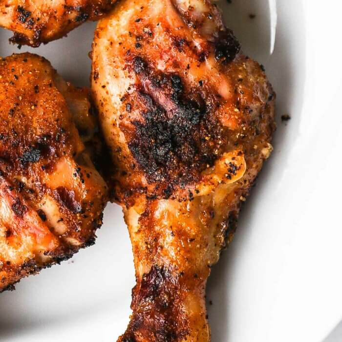 Close up overhead shot of 3 grilled chicken legs on a plate