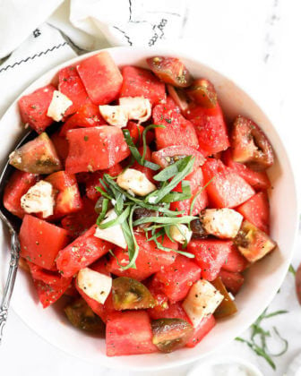 Close up image of tomato watermelon salad in a bowl with fresh chopped basil on top.