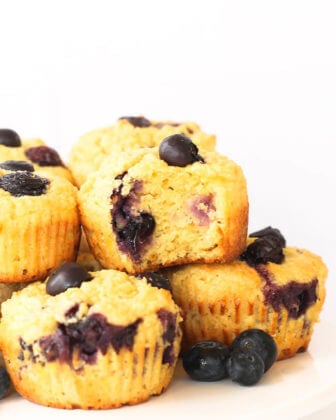 Gluten free lemon blueberry muffins on a cake stand.