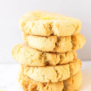 Stack of five gluten free shortbread cookies with lemon zest sprinkled on top.