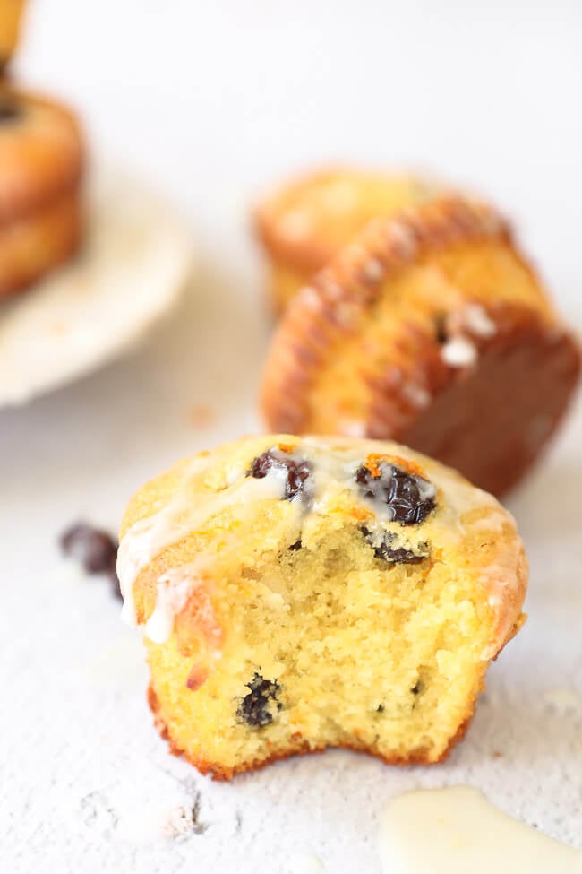 Close up angled image of one orange cranberry muffin with a bit taken out of it. 