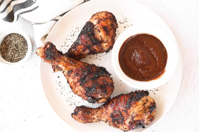 Des pilons de poulet grillés sur une assiette avec de la sauce BBQ image horizontale