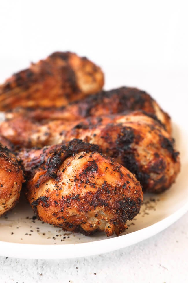 Grilled chicken drumsticks on a plate close up angle image