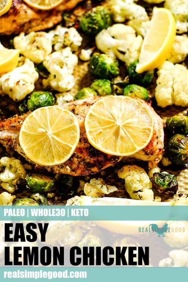 Close up of easy lemon chicken with roasted brussels and cauliflower on a sheet pan with lemon slices. Long pin for pinterest. 