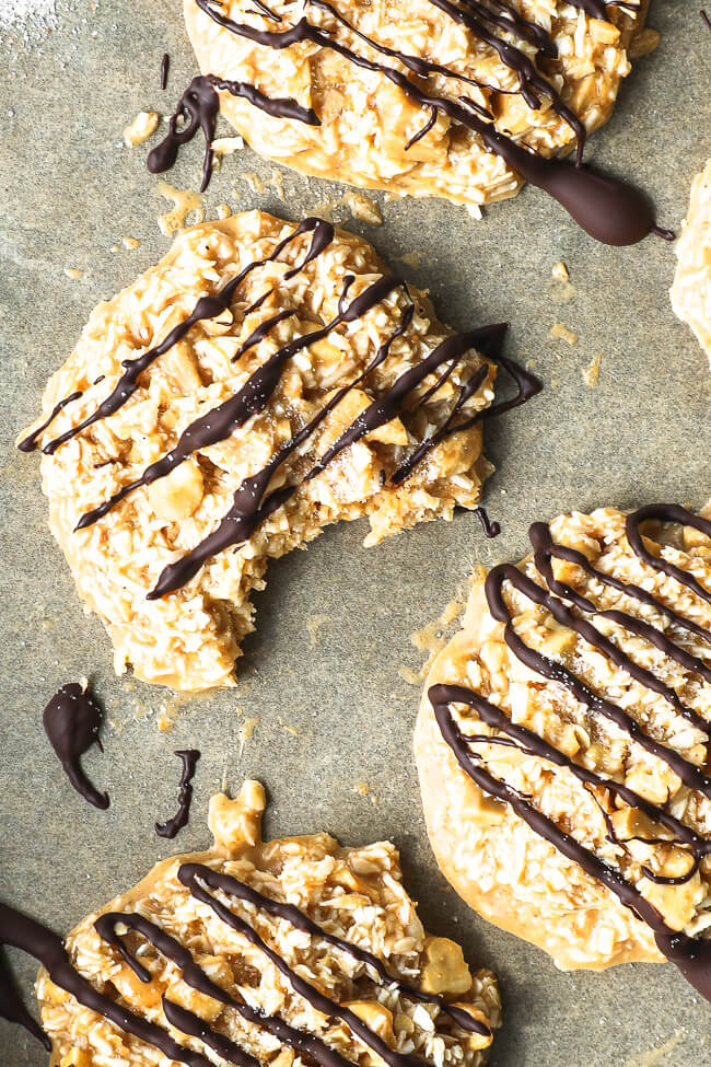 Close up of cbd cookies with chocolate drizzled on top. One cookie with a bite taken out of it. 