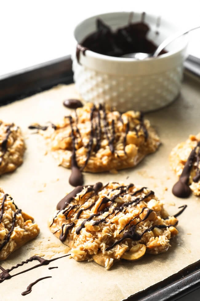 Angled image of no bake cbd cookies on a cookie sheet drizzled with chocolate on top. 