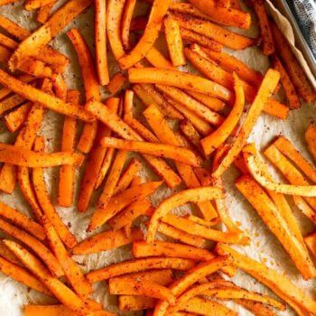 Vertical overhead image of butternut squash fries on a baking sheet.