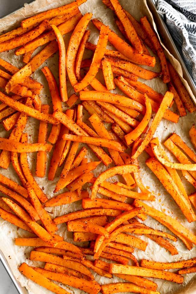 Vertical overhead image of butternut squash fries on a baking sheet.