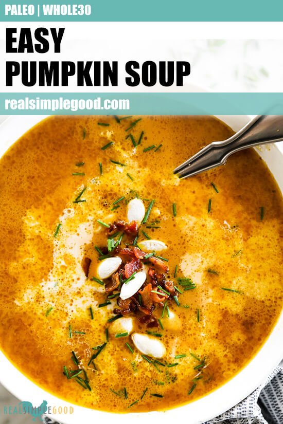 Vertical overhead close up image of pumpkin soup in a bowl with a spoon. Topped with bacon bits, pumpkin seeds and chopped chives. Text overlay at top. 