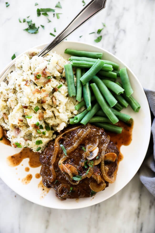Easy salisbury steak on plate with green beans and mashed cauliflower overhead shot.