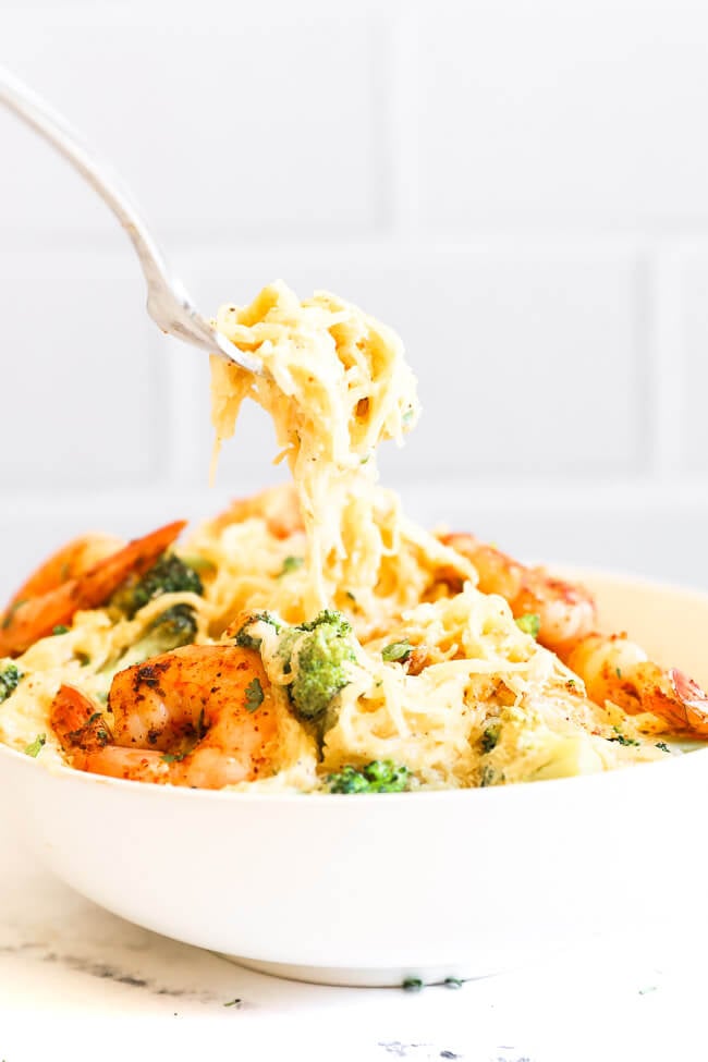 Image of scooping a forkful of spaghetti squash alfredo out of a bowl. 