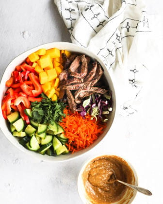 Easy thai beef salad with chopped veggies in bowl and sauce on the side