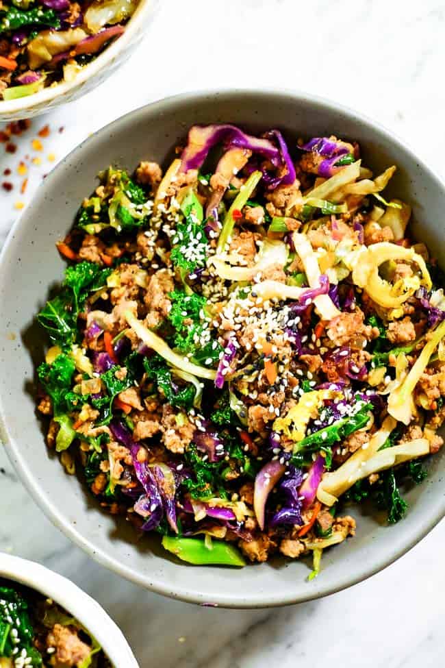Egg roll in a bowl topped with sesame seeds. Made with cruciferous veggies, ground pork and a savory sauce. 