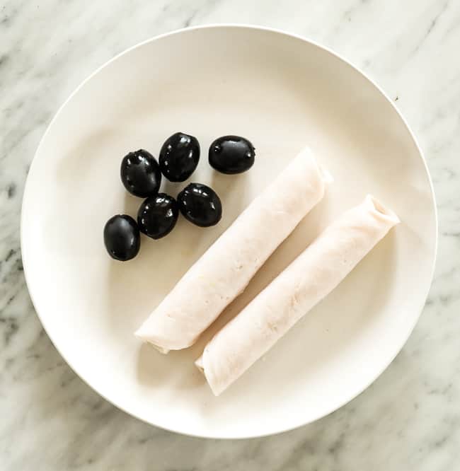 Olives and rolled lunch meat on a plate