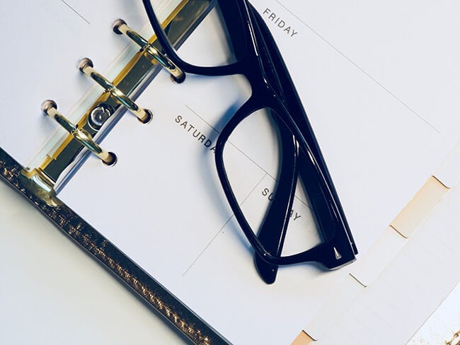 Close up of calendar planner with black glasses on top