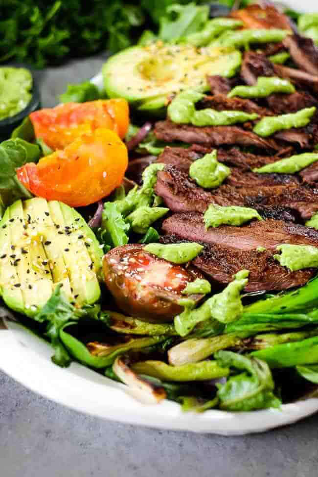 Grilled steak salad with greens, bok chow, tomatoes, green onion, avocado and green dressing. 