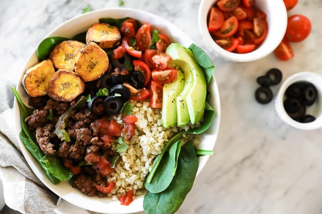 ground beef taco bowl with greens, plantains and cauli rice horizontal image 