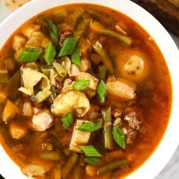 Overhead image of hamburger soup in a bowl with potatoes, mushrooms and chopped green onions