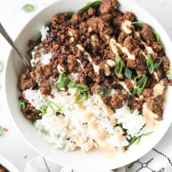 Close up overhead shot of single korean beef bowl with rice and spicy mayo topping