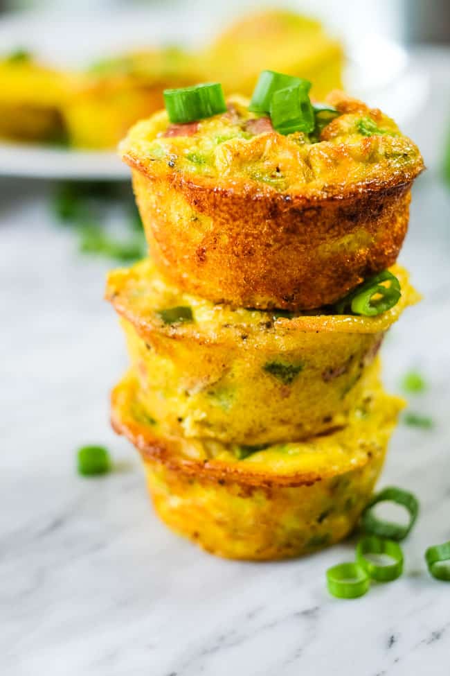 Healthy egg muffins stacked with chopped green onion. 