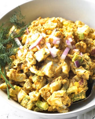Close up overhead shot of healthy egg salad in a bowl with red onion topping