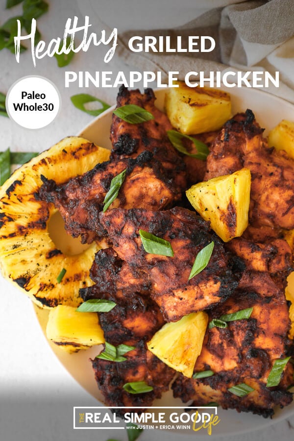 Close up of grilled pineapple chicken on a plate with chopped green onion on top. Text overlay at top of image. 