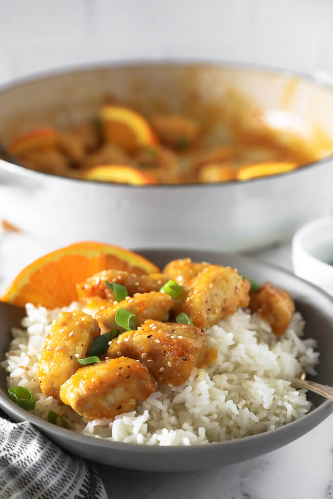 Healthy orange chicken in a bowl over rice angled vertical image