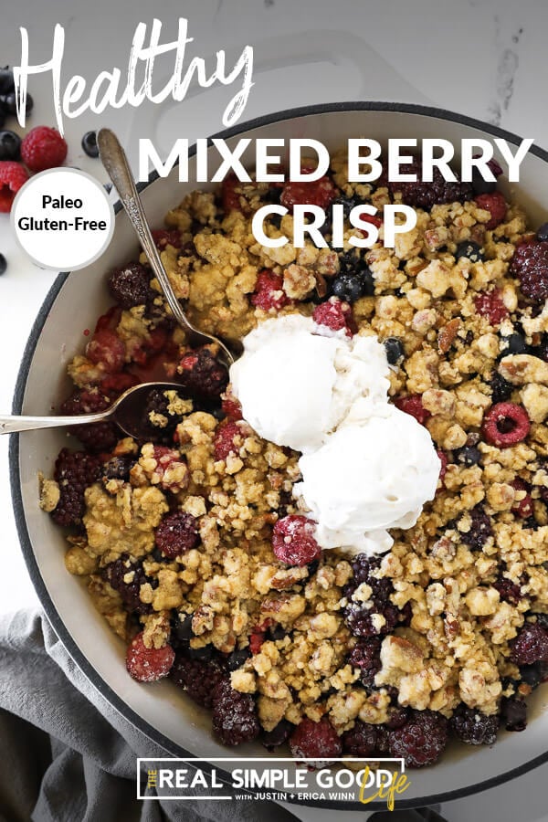 Overhead vertical image of mixed berry crisp in skillet with two spoons dug in and two scoops of ice cream on top. Text overlay at top. 