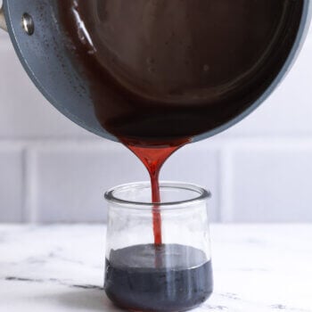 Pan pouring grenadine syrup into a jar