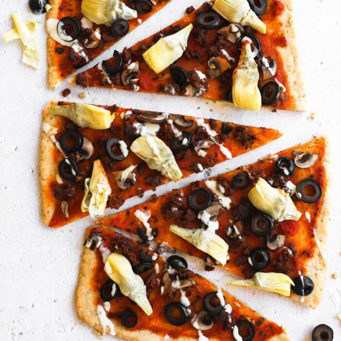 Gluten free flatbread pizza cut into slices and lined up vertically with ranch drizzled on top.