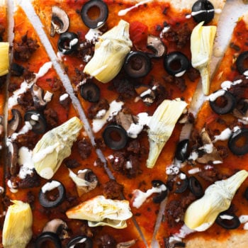 Gluten free flatbread pizza sliced into pieces with ranch drizzled on top.