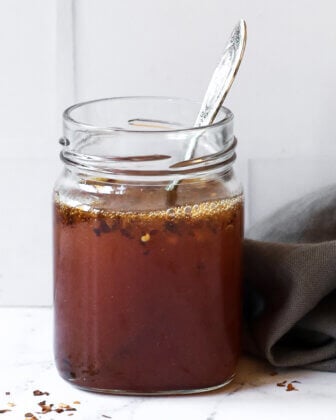 Hot honey sauce in a jar with spoon sticking out