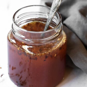 Close up angle shot of hot honey sauce in a jar with spoon sticking out