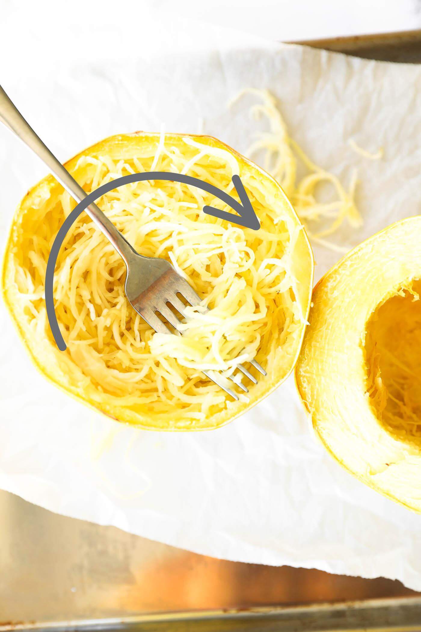 Cooked half of a spaghetti squash with noodles and an arrow showing which direction the noodles grow