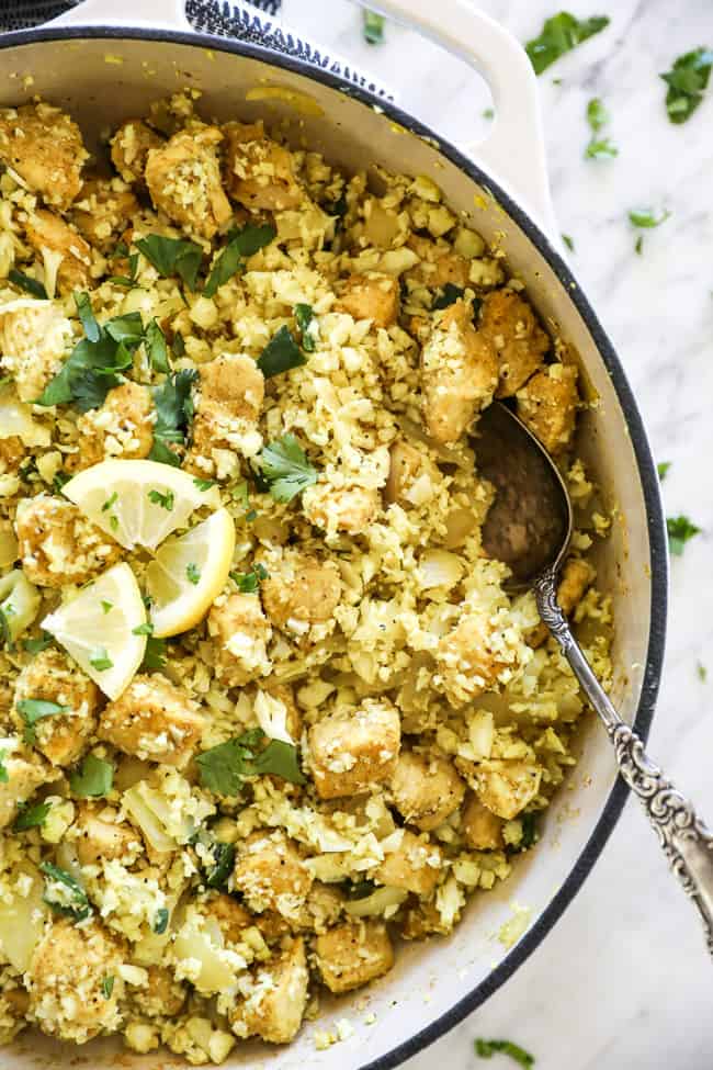 Overhead shot of indian chicken in pan with spoon on the side