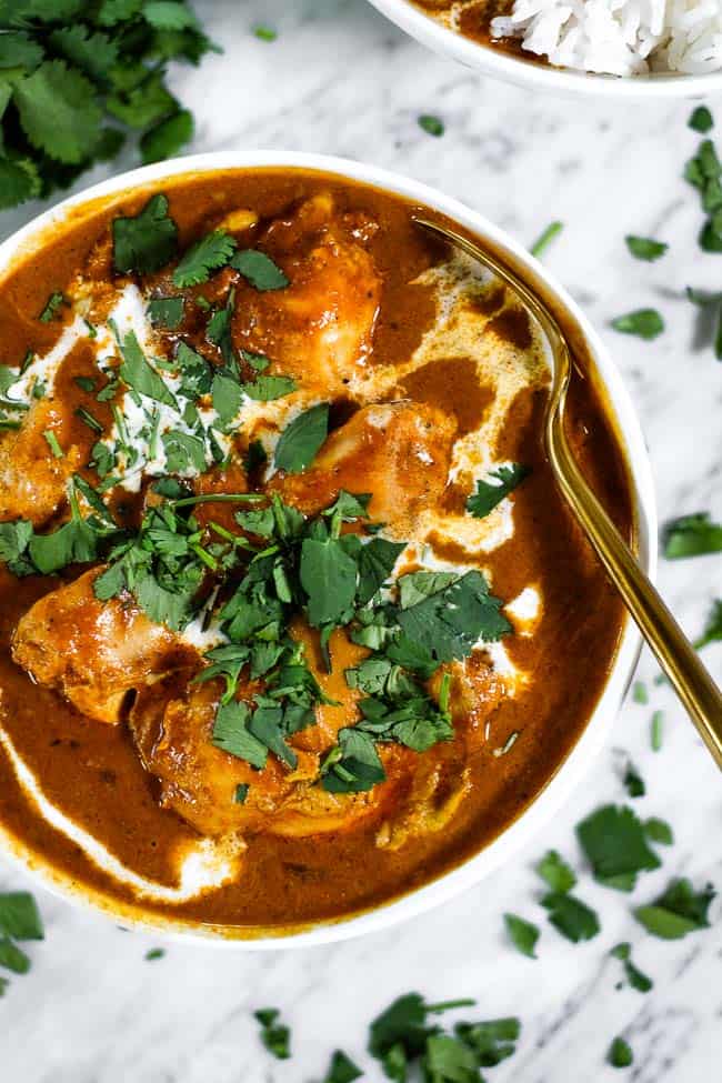 Butter chicken in bowl with sauce and chopped cilantro on top