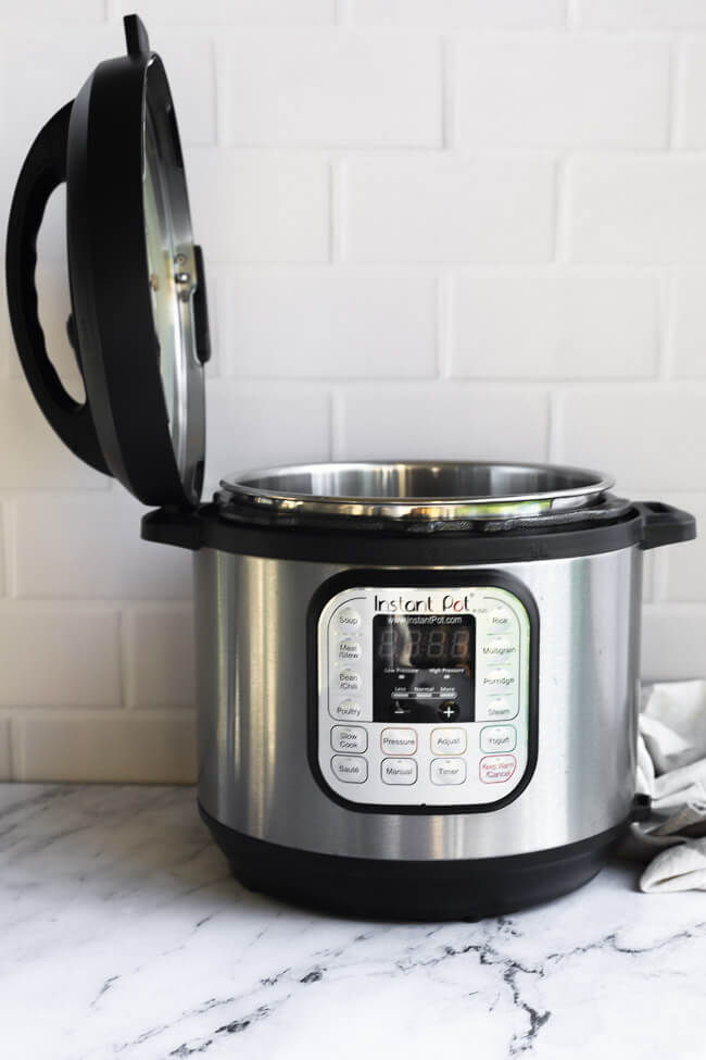 Straight on image of an instant pot with the lid sideways in the built in lid holder