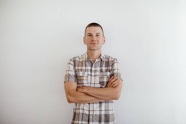 Justin Winn standing with arms crossed horizontal image