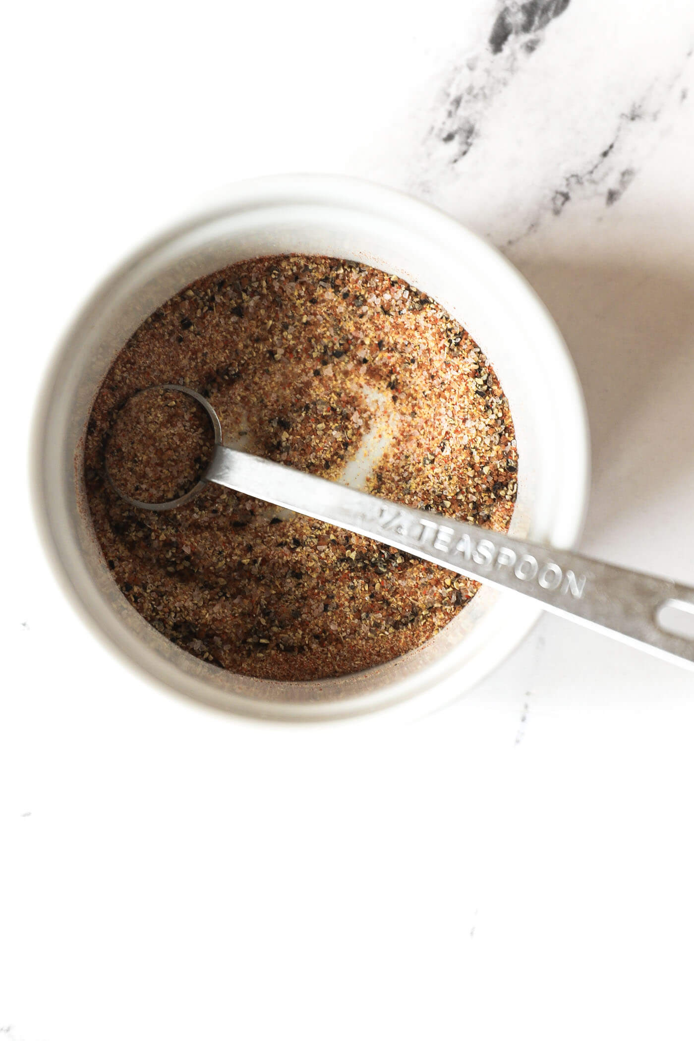 Seasonings combined in a ramekin with a measuring spoon.